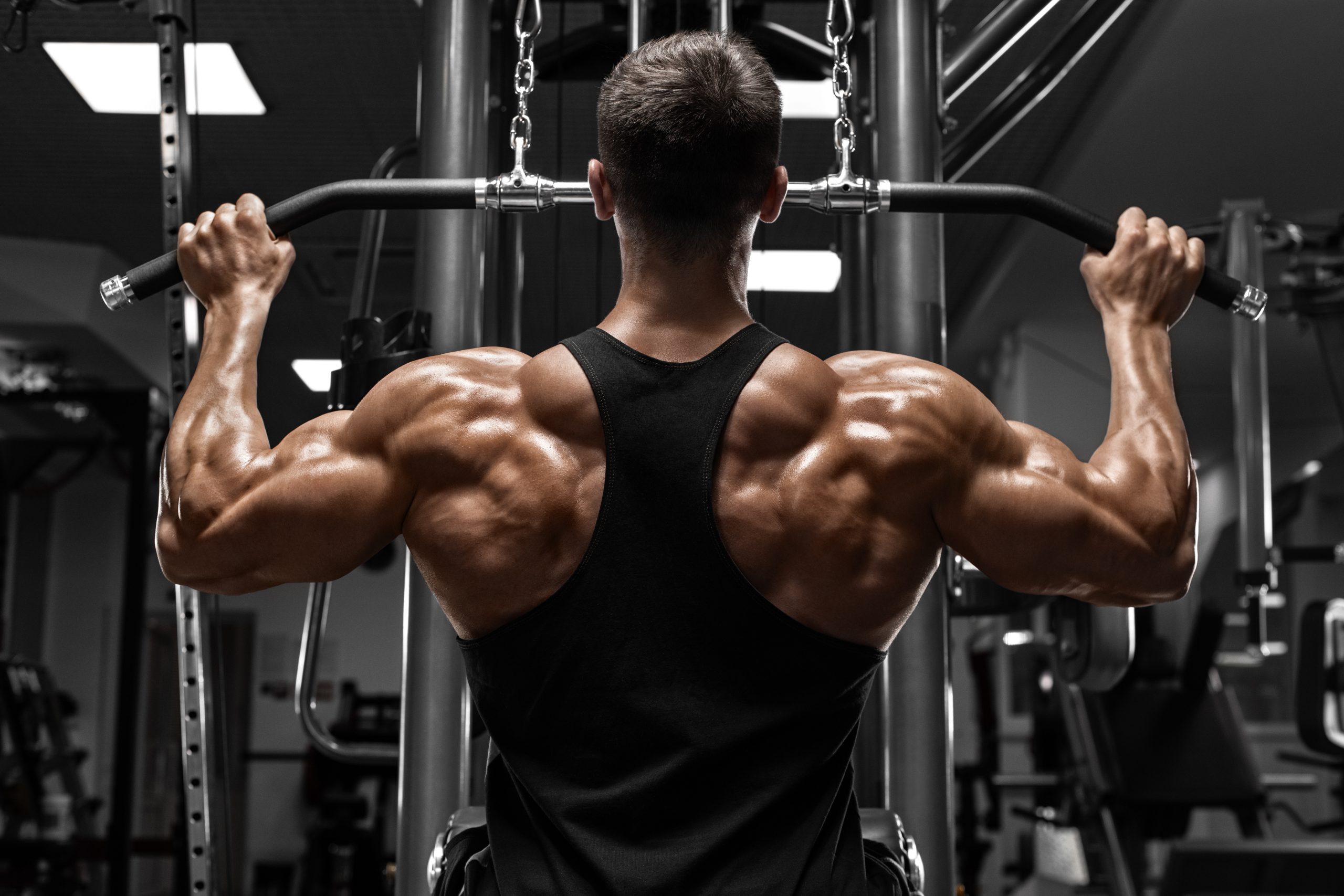 Muscular man workout in gym, doing exercise for back lat pulldow